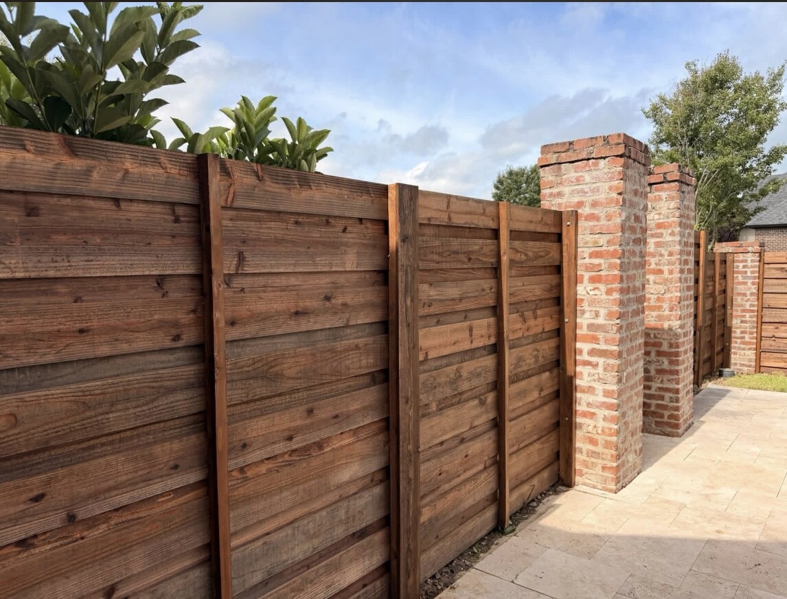 Horizontal wood privacy fencing built between brick columns